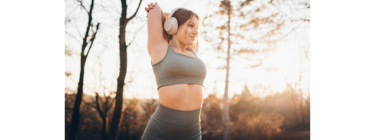 Woman stretching outdoors to support muscle recovery, amino acids and daily wellness